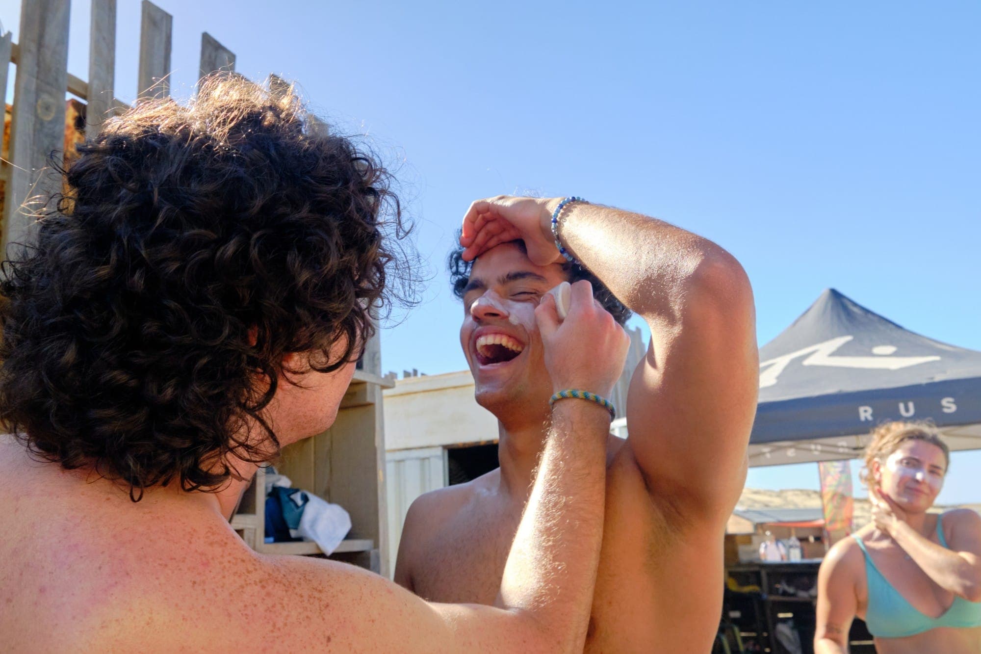 Risas poniéndose crema solar antes de surfear
