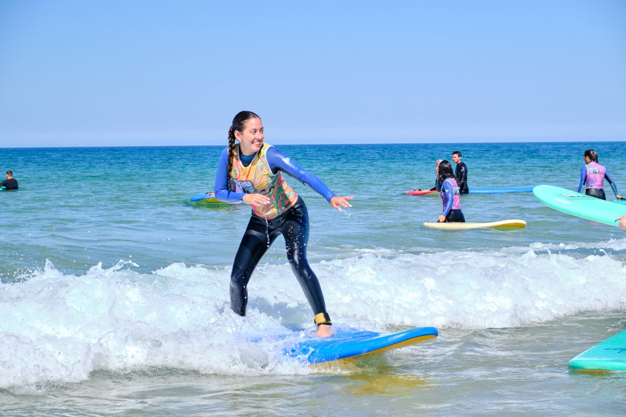 Participante cogiendo una ola en clase de surf